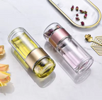 Two tea glass infuser bottles with floral elements on a light background