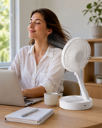 Portable desk fan cooling a home office workspace